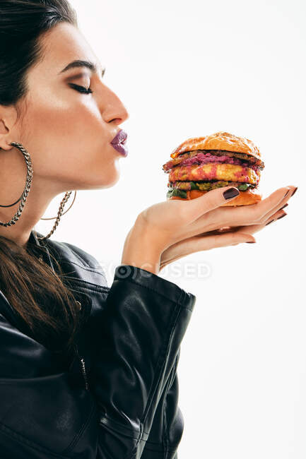 Mulher na moda segurando hambúrguer com lábios beijo — Fotografia de Stock