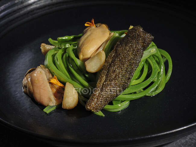 Viande exquise avec des légumes à l'ail servis sur un large plat noir — Photo de stock