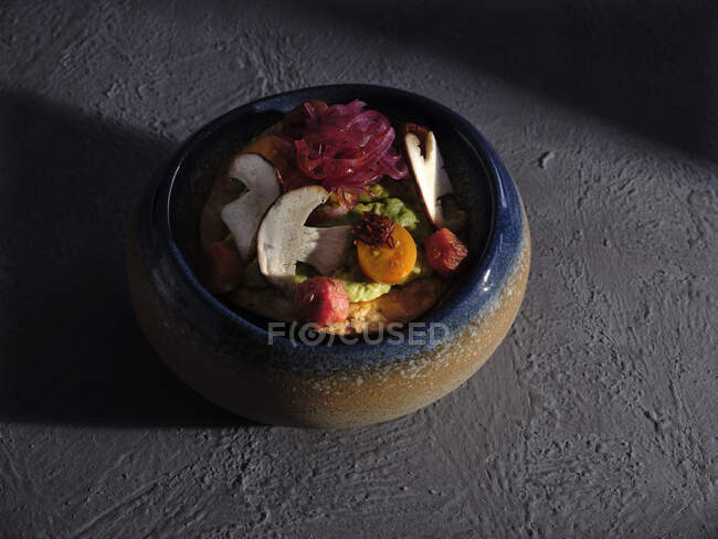Enorme ciotola piena di insalata con funghi tagliati a metà e verdure sulla superficie del cemento — Foto stock