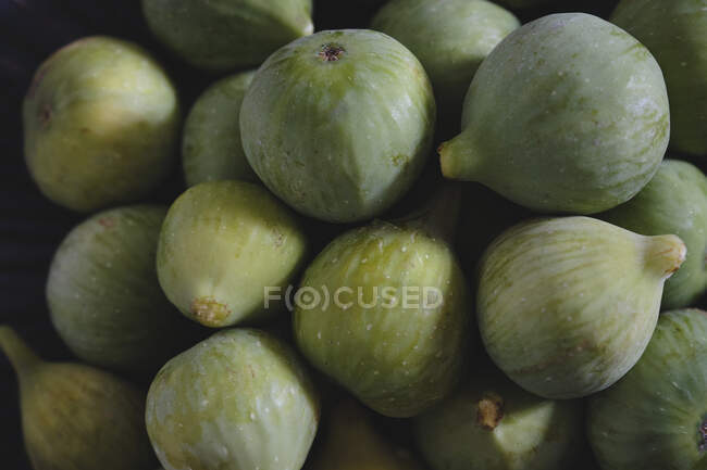 Du dessus du bol décoratif bleu rempli de figues fraîches et douces sur une table en bois sombre — Photo de stock