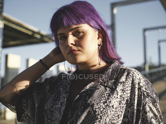 Портрет стильної жінки з фіолетовою зачіскою дивиться в камеру — стокове фото