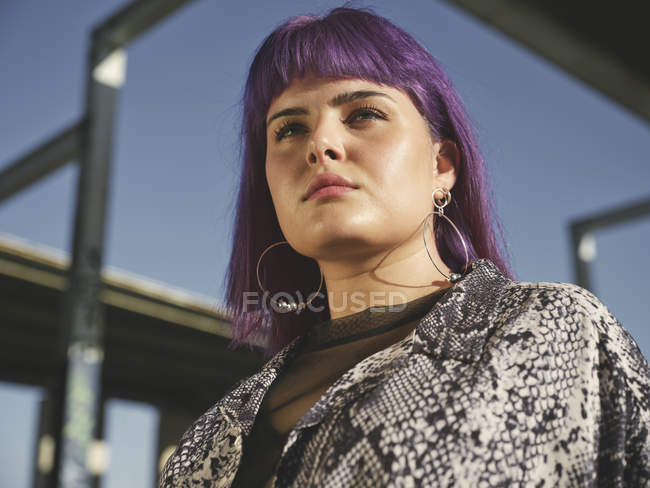 Portrait of beautiful young woman with purple hairstyle standing outdoors — Stock Photo