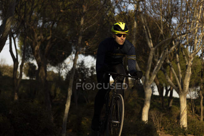 Man cyclist training on the bike lane in a park — Stock Photo
