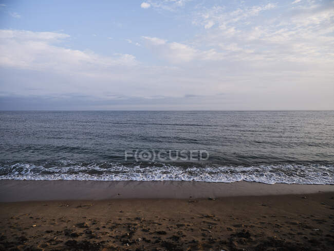 Serena playa de arena y olas de luz - foto de stock