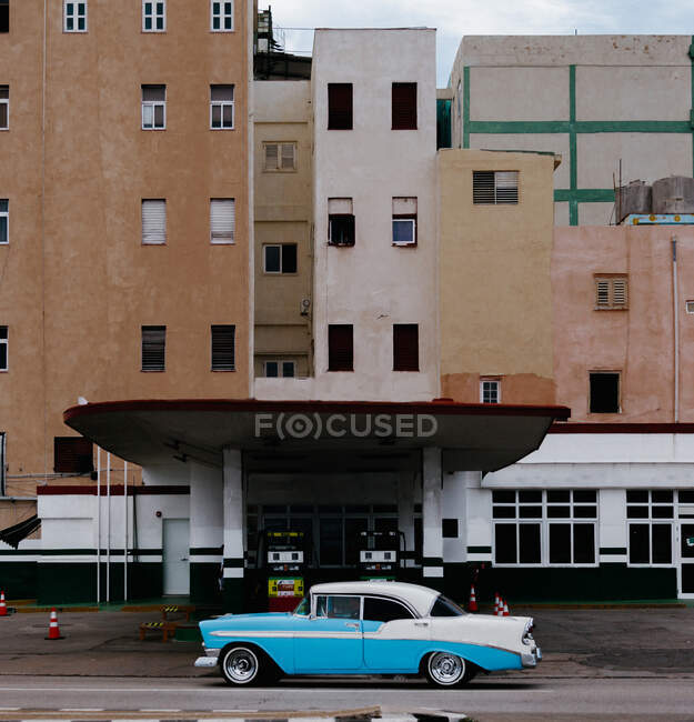 Seitenansicht eines blauen Oldtimers auf einer Asphaltstraße in der Nähe einer Tankstelle in Kuba — Stockfoto