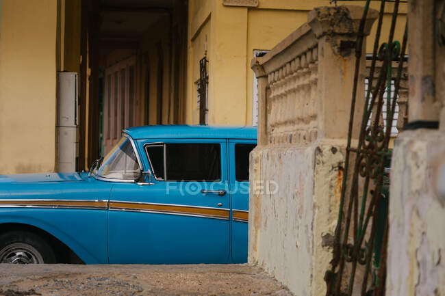 Piccola strada con auto d'epoca sul ciglio della strada tra edifici storici colorati con bar alle finestre a Cuba — Foto stock