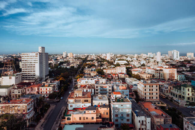 D'en haut de bâtiments colorés et gratte-ciel avec ciel bleu sur fond dans les rues de Cuba — Photo de stock