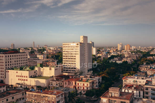 Desde arriba de coloridos edificios y rascacielos con cielo azul sobre fondo en las calles de Cuba - foto de stock