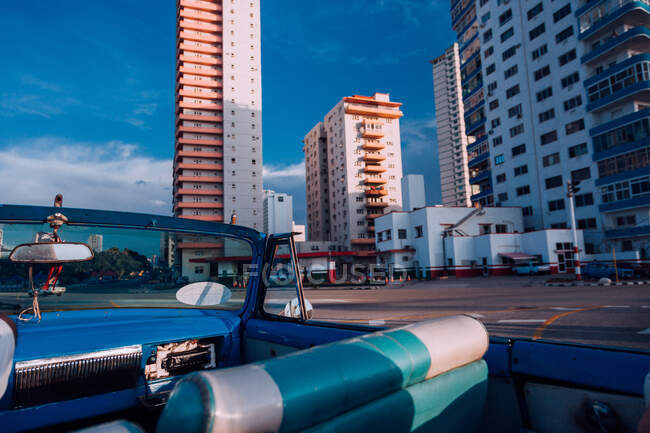 Синий ретро-автомобиль с открытым верхом на городской улице со старыми зданиями — стоковое фото
