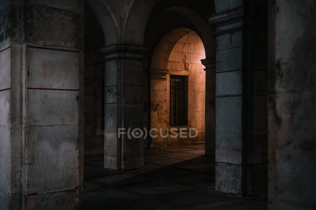 Lanterna vecchio stile che illumina gli archi squallidi dell'antico edificio della cattedrale di notte a Burgos, Spagna — Foto stock