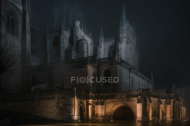 Cerca de pedra iluminada em torno do antigo edifício da catedral na noite escura enevoada em Burgos, Espanha — Fotografia de Stock