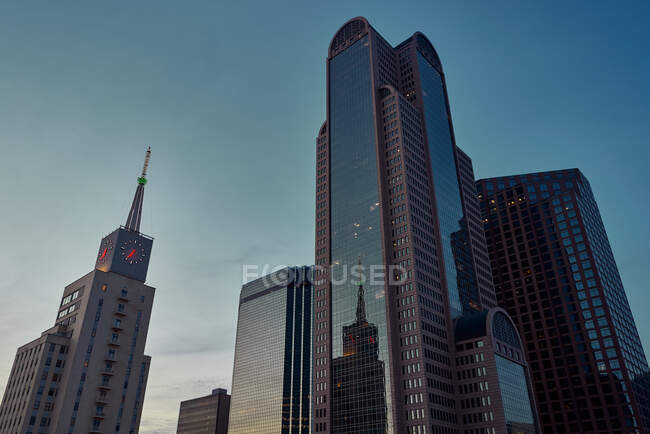 Von unten moderne Wolkenkratzer mit blauem Himmel im Hintergrund in der Abenddämmerung in Dallas, Texas, USA — Stockfoto