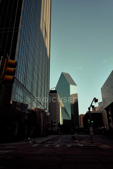 Estrada de asfalto vazia em meio a grandes edifícios de óculos com céu azul no fundo ao entardecer em Dallas, Texas Nova York — Fotografia de Stock
