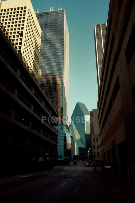 Carrefour d'asphalte vide au milieu de grands bâtiments de lunettes avec ciel bleu sur le fond à la tombée de la nuit à Dallas, Texas New York — Photo de stock