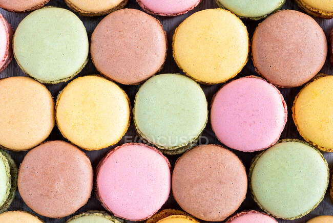 Macarons savoureux colorés affichés en surface en bois — Photo de stock
