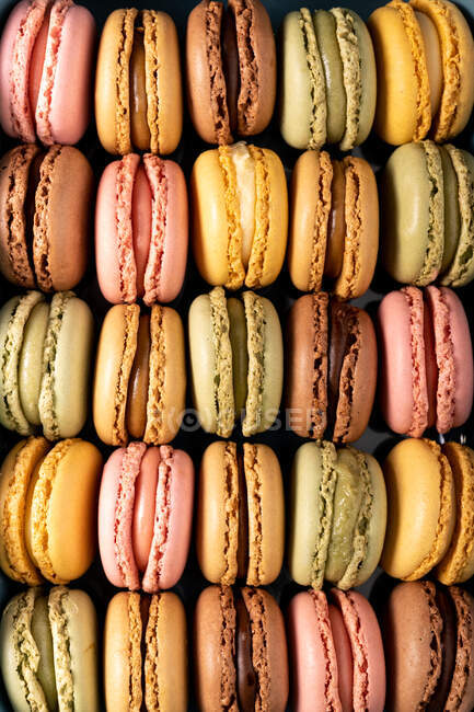 Colorful tasty macaroons displayed on black background — Stock Photo