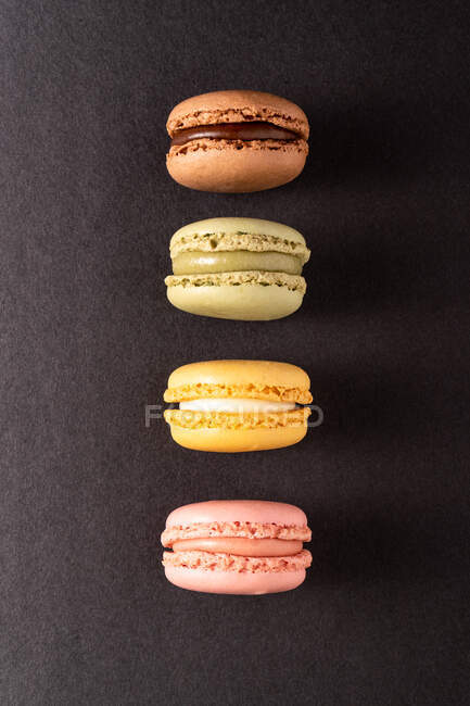 Macaroni gustosi colorati visualizzati su sfondo nero — Foto stock