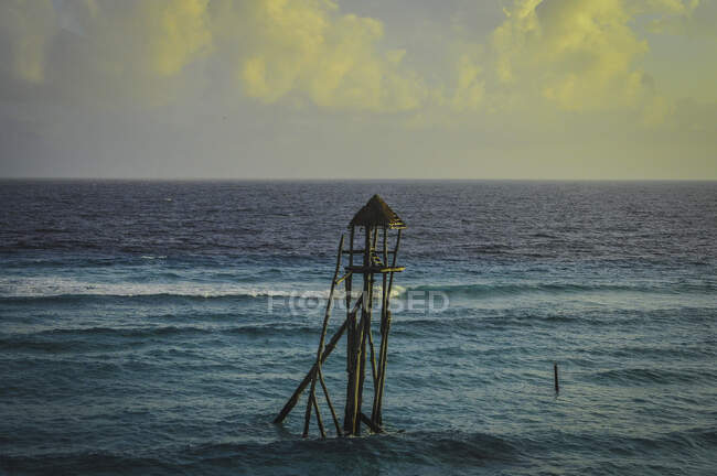 Incroyable paysage de poste d'observation solitaire vide sous un ciel jaune nuageux dans l'océan turquoise — Photo de stock