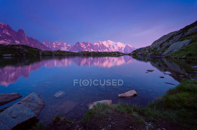 Хрустальное озеро, отражающее снежные горы в яркий день — стоковое фото
