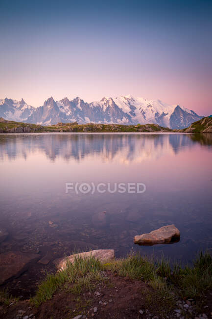 Crystal lake reflecting snowy mountains in bright day — Stock Photo