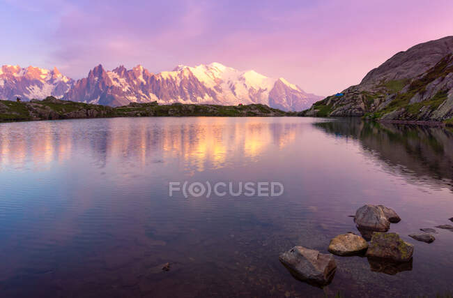 Crystal lake reflecting snowy mountains in bright day — Stock Photo