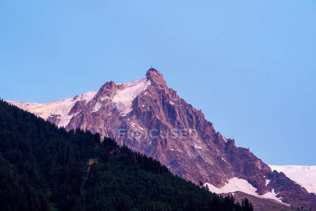 Picchi bianchi di montagna taglienti nella neve che si innalzano fino al cielo nuvoloso — Foto stock