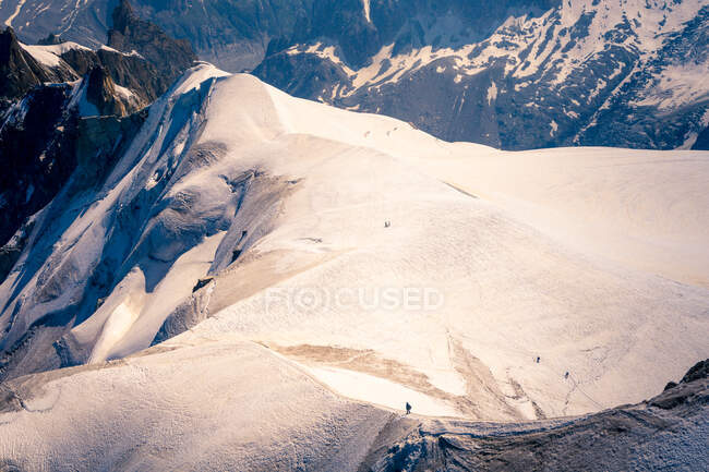 Lugar nevado no topo das montanhas sob o céu brilhante — Fotografia de Stock