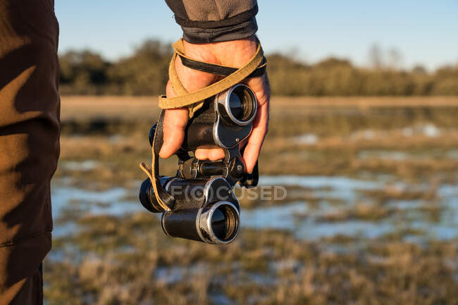 Cropped unrecognizable man looking through an old binoculars the fauna of a lagoon in Spain — Stock Photo
