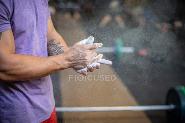 Athlete spreading magnesium on hands — Stock Photo