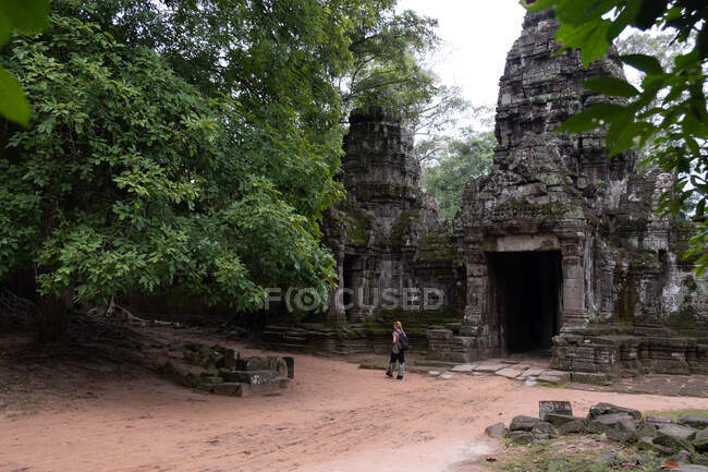 Вид на безликого путешественника, смотрящего религиозный храм Ангкор-Ват в Камбодже — стоковое фото