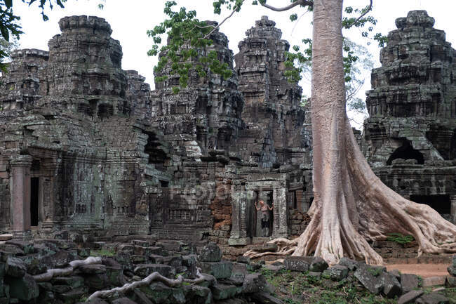 Mujer sin rostro de pie sobre las ruinas del antiguo templo religioso Angkor Wat en Camboya - foto de stock