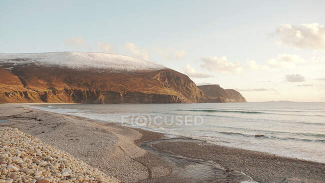 Pintoresco paisaje de majestuosas cordilleras nevadas y costa arenosa en Irlanda - foto de stock