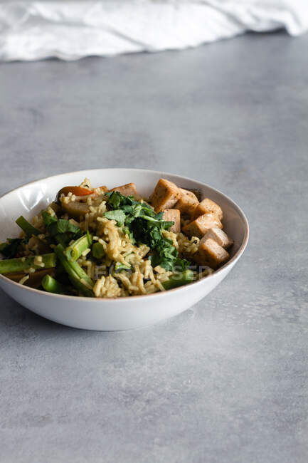 Von oben leckeres gekochtes Gericht mit Reis und grünen Bohnen, serviert auf Tellern mit Gewürzen auf dem Tisch — Stockfoto