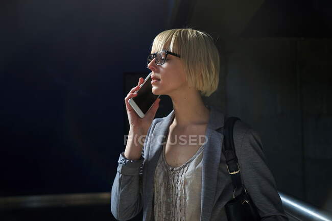 Mujer de negocios rubia hablando en el teléfono inteligente - foto de stock