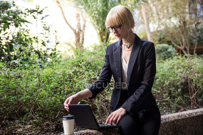 Junge Geschäftsfrau sitzt und nutzt Tablet — Stockfoto