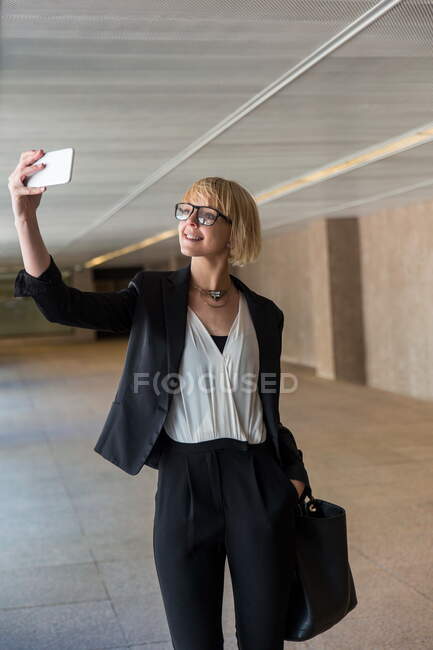 Donna d'affari che utilizza smartphone in sala — Foto stock