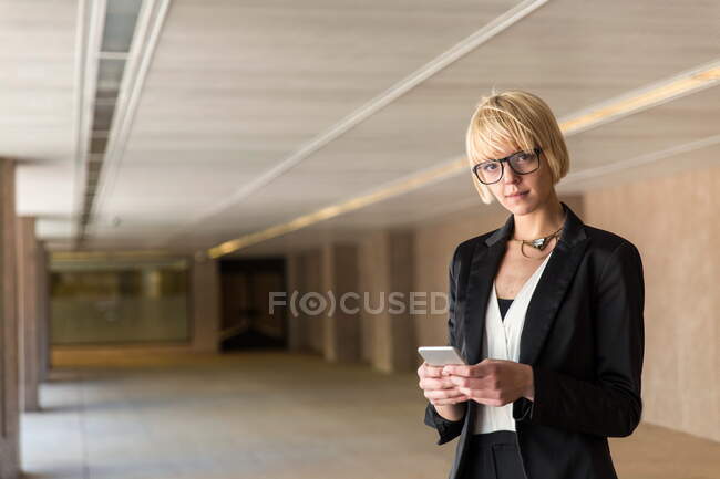 Elegante smartphone di navigazione donna d'affari — Foto stock