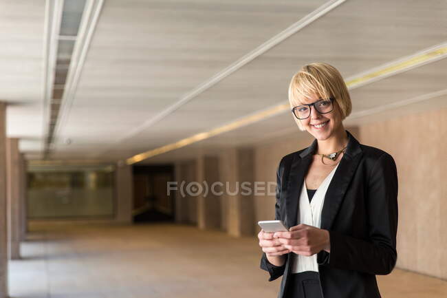 Stylish businesswoman browsing smartphone — Stock Photo