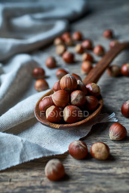 Brown ripe hazelnuts on spoon at table — Stock Photo