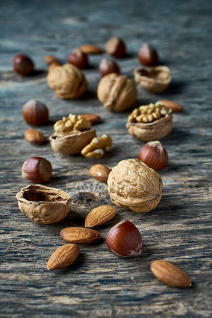 Brown ripe hazelnuts and walnuts at table — Stock Photo
