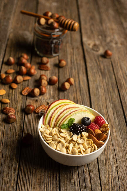 Зверху миска з горіхами фрукти та ягоди здорова їжа на дерев'яному столі — стокове фото