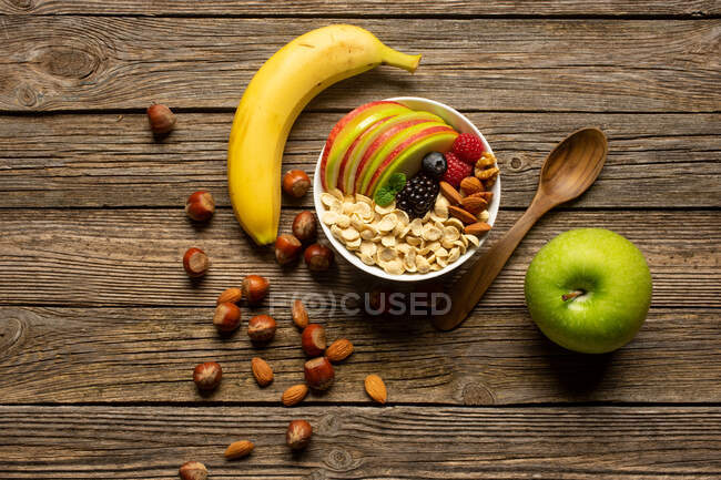 Apple and banana with nuts on wooden table — Stock Photo