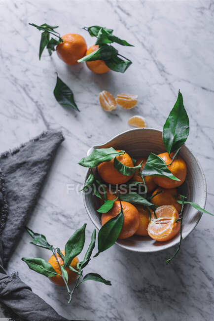 Mandarines orange dans un bol décoratif en céramique sur une table en marbre — Photo de stock