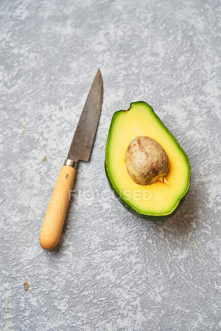 Cut avocado on grey texture background — Stock Photo