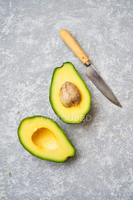 Вырезать авокадо на сером фоне текстуры — стоковое фото