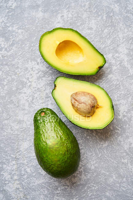 Taglia l'avocado su sfondo grigio — Foto stock