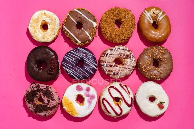 Draufsicht des Sortiments von leckeren süßen glasierten Donuts mit Zuckerguss und Schokolade dekoriert — Stockfoto