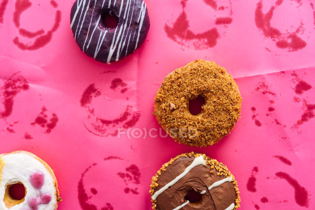 Varietà di ciambelle su sfondo rosa — Foto stock