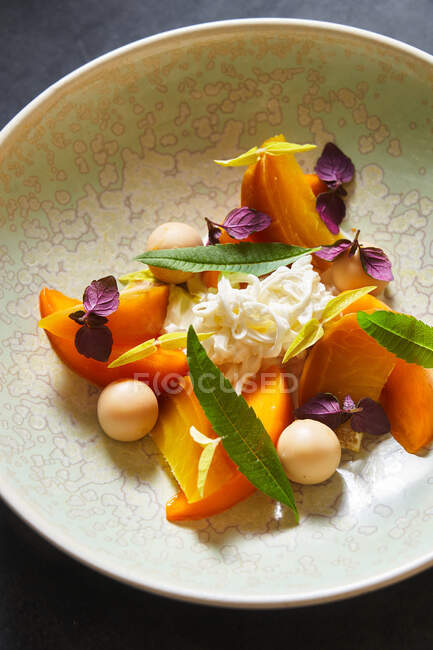 Vue du dessus de la portion de salade de mangue délicieuse avec des herbes placées sur l'assiette sur la table grise dans le café — Photo de stock