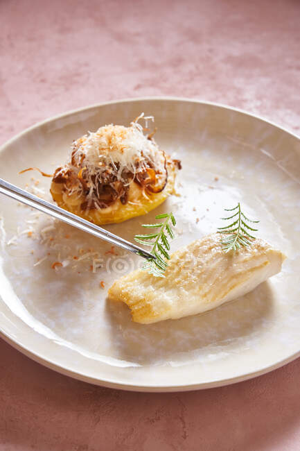Salsa crema a plato de pescado delicioso con hierba sobre fondo rosa en el restaurante - foto de stock